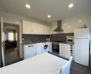 a kitchen with white appliances and a white refrigerator at Casa da Formosa in Silveira