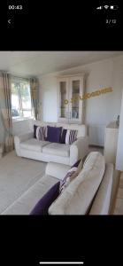 a living room with two white couches in a room at Lodge for Hire in Pagham