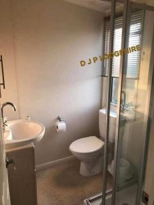 a bathroom with a toilet and a sink at Lodge for Hire in Pagham