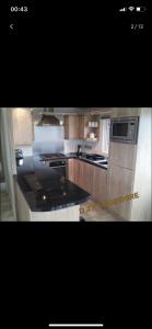 a large kitchen with wooden cabinets and appliances at Lodge for Hire in Pagham