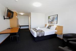 a hotel room with a bed and a desk at Blue Shades Motel in Maryborough