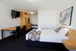 a hotel room with a bed and a desk at Blue Shades Motel in Maryborough