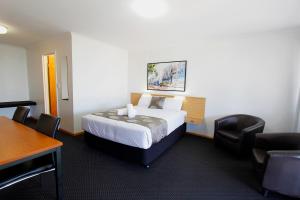 une chambre d'hôtel avec un lit, une table et des chaises dans l'établissement Blue Shades Motel, à Maryborough