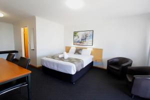 Habitación de hotel con cama, mesa y sillas en Blue Shades Motel, en Maryborough