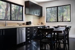 a kitchen with black cabinets and a table with chairs at Ablac House in Glenlyon