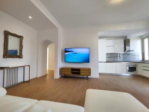 een woonkamer met een flatscreen-tv aan de muur bij Attico Vespucci Luxury Penthouse in Olbia