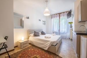 1 dormitorio blanco con 1 cama y cocina en Olga's Rooms, en Verona