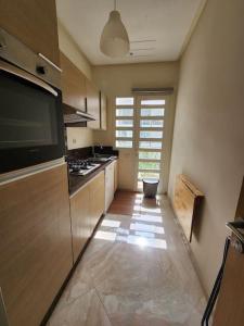 a kitchen with a stove and a counter top at Casabay Sidi Rahal plage vue sur piscine et mer in Sidi Rahal