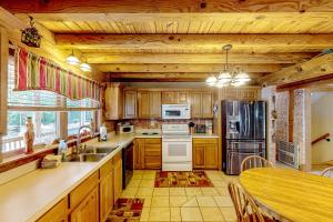 een keuken met houten kasten en een tafel en een aanrecht bij Spring Creek Pinnacle in Lake Murray Shores