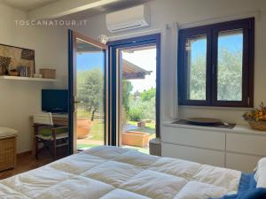 1 dormitorio con 1 cama y puerta corredera de cristal en Cottage Lavanda con vista mare, aria condizionata by ToscanaTour en Guardistallo
