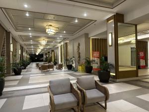 a hallway with chairs and plants in a building at CELANDINE Residence by DMCI in Manila