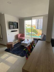 a living room with a couch and a table at Amplio y acogedor apartamento cerca al Cable Plaza in Manizales