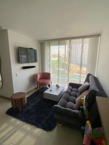 a living room with a couch and a chair at Amplio y acogedor apartamento cerca al Cable Plaza in Manizales