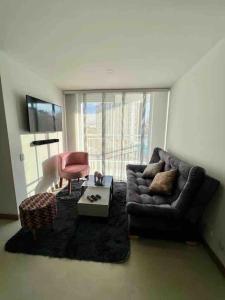 sala de estar con sofá y silla en Amplio y acogedor apartamento cerca al Cable Plaza en Manizales