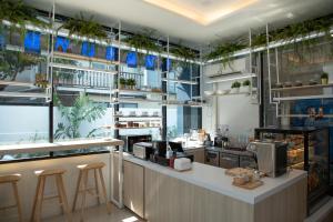 ein Restaurant mit Pflanzen an den Wänden und einer Theke in der Unterkunft J & L Residence and Spa in Ban Khlong Khwang Klang