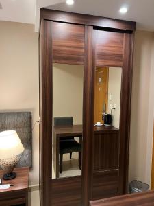 a room with a wooden partition with a table and a mirror at Exclusiva Suíte Granja Brasil in Petrópolis