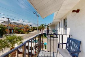 einen Balkon mit einem blauen Stuhl auf einem Haus in der Unterkunft The Shuttle Beach House in Cape Canaveral