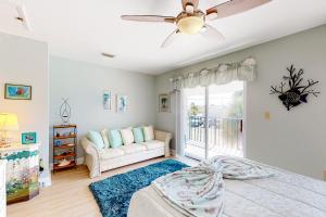 a bedroom with a bed and a couch and a window at The Shuttle Beach House in Cape Canaveral
