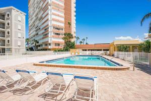 a group of chairs and a swimming pool at Beachside Retreat W Heated Pool in St. Pete Beach