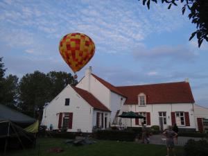 a hot air balloon flying over a house at B&B Hullebrug in Heist-op-den-Berg