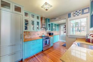 uma cozinha com armários azuis e um lavatório em The Robins Nest em Annapolis