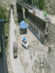 Una camioneta blanca estacionada al lado de un edificio y un camión en Sharda Palace by StayApart, en Barkot