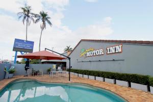 a hotel with a swimming pool in front of a building at Sugar Country Motor Inn in Bundaberg
