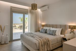 a bedroom with a bed and a sliding glass door at AL MARE VILLAS in Lixouri