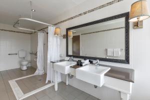 uma casa de banho com 2 lavatórios e um espelho grande em Nimbo Fork Lodge em Gocup