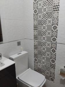łazienka z toaletą i ścianą wyłożoną kafelkami w obiekcie Piso turístico en el centro de Benavente w mieście Benavente +37 zdjęć
