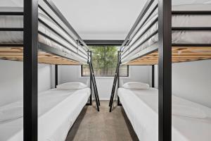 two bunk beds in a room with a window at Cowrie Central Townhouse in Torquay