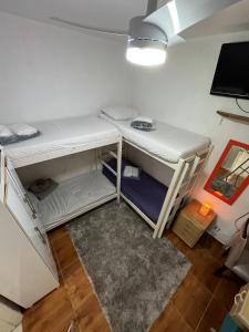 een kamer met een wit stapelbed en een tv bij Coliving Vila Mariana in Sao Paulo