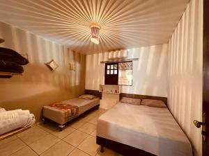 a bedroom with two beds and a ceiling at Casa Mara Milagres in Passo de Camarajibe