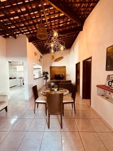 a dining room and living room with a table and chairs at Casa Mara Milagres in Passo de Camarajibe