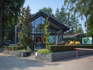 une maison avec un toit noir dans une rue dans l'établissement Luxury lodge with private swimming pool, located on a holiday park in Rhenen, à Rhenen