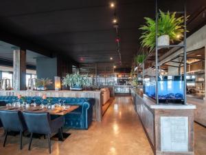 comedor con mesa y sillas azules en Modern design lodge directly at the water, in national park, en Tholen