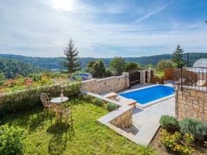 帕津的住宿－Charming holiday home in Pazin with private pool，一个带桌椅的花园和一个游泳池