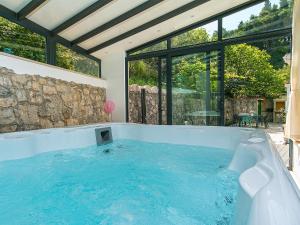 una vasca idromassaggio al centro di una stanza con finestre di Stone House in Podgora with Sea Views a Podgora