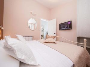 una camera da letto con un grande letto bianco con cuscini bianchi di Stone House in Podgora with Sea Views a Podgora Altre 32 foto