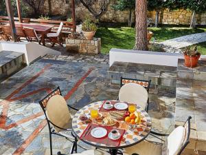 a table and chairs with food on a patio at Seaside Serenity Stay in Karteros