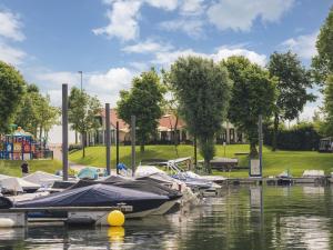 un grupo de barcos están atracados en un puerto deportivo en Luxury holiday home on the water, located in a holiday park in the Betuwe, en Maurik