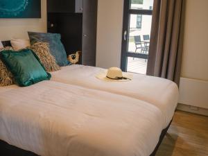 1 dormitorio con 1 cama con sombrero en Luxury holiday home on the water, located in a holiday park in the Betuwe, en Maurik
