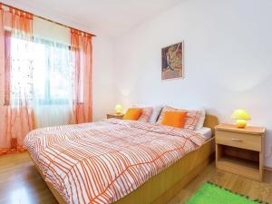um quarto com uma cama com almofadas laranja e uma janela em Inviting Apartment in Vinkuran near Sea em Vinkuran
