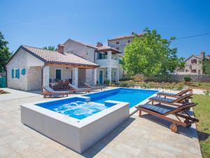 eine Villa mit einem Pool vor einem Haus in der Unterkunft Roofed Villa in Istria with Private Pool and Garden in Rajki