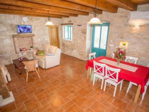 ein Wohnzimmer mit einem roten Tisch und Stühlen in der Unterkunft Roofed Villa in Istria with Private Pool and Garden in Rajki