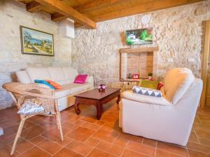 ein Wohnzimmer mit einem Sofa und einem Tisch in der Unterkunft Roofed Villa in Istria with Private Pool and Garden in Rajki