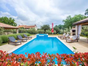 einen Pool mit Liegestühlen und einer Terrasse in der Unterkunft Roofed Villa in Istria with Private Pool and Garden in Rajki