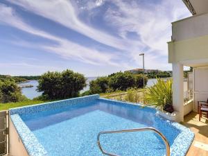 einen Pool mit Blick auf das Wasser in der Unterkunft Deluxe Villa in Pula with Private Swimming Pool in Pješčana Uvala