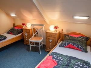 um pequeno quarto com 2 camas e uma cadeira em Beautiful group accommodation with hot tub and Finnish kota, located in Twente em Losser