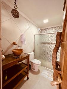 a bathroom with a toilet and a glass shower at Casa Mara Milagres in Passo de Camarajibe +30 photos